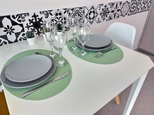 Moussy-le-NeufにあるLe Soléoの白いテーブル(皿、ワイングラス付)