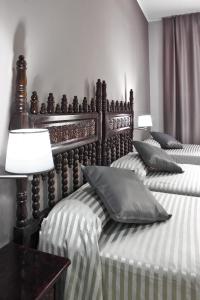 バルセロナにあるホテル イングレスのベッドルームに枕付きのベッド2台が備わります。