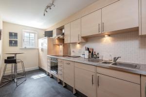 kuchnia z białymi szafkami i zlewem w obiekcie Adamson Court - 2 Bedroom Flat - Free Parking w mieście St Andrews