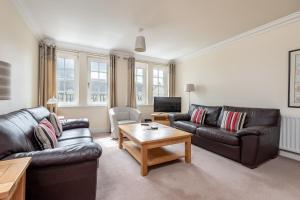 a living room with leather couches and a coffee table at Adamson Court - 2 Bedroom Flat - Free Parking in St. Andrews