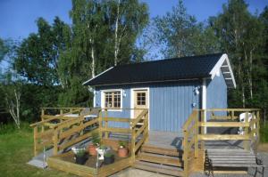 un pequeño cobertizo azul con rampa y terraza en Lussebo 9, en Lidköping