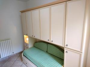 um quarto com armários brancos e uma cama verde em Grottammare mon amour Gigì em Grottammare
