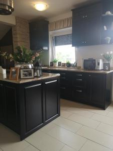 a kitchen with black cabinets and a counter top at Apartma Isabella in Sečovlje
