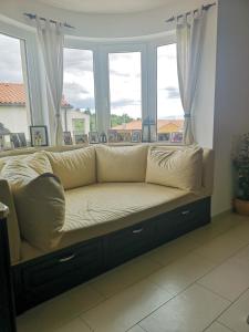 a couch sitting in front of a window at Apartma Isabella in Sečovlje