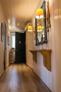 a hallway with a mirror and a black door at Cal Sisquet - TON in La Seu d'Urgell