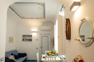 uma sala de estar com um sofá azul e um espelho em La Rosa dei Venti - Scirocco em Amalfi