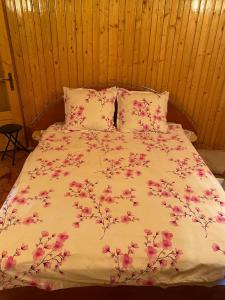 a bed with pink flowers on it in a bedroom at Casa Alesi in Dragoslavele +64 photos