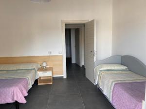 ein Zimmer mit 2 Betten und einem Nachttisch dazwischen in der Unterkunft Residenza Mediterraneo in Bellaria-Igea Marina