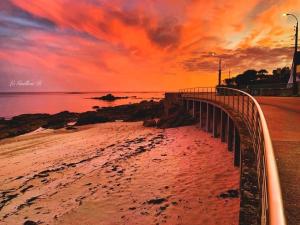 a pier on the beach with a sunset at Duplex calme et cosy in Concarneau