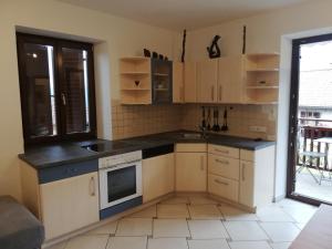 małą kuchnię z białymi szafkami i oknem w obiekcie Haus Möltner - Apartment Aviam w mieście Caldaro