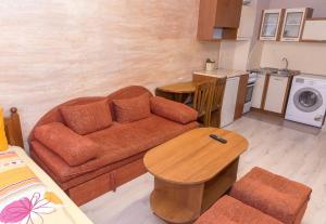 a living room with a couch and a table at Къща за гости Мони in Sandanski +9 photos