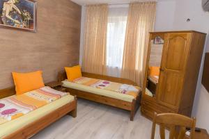 a small room with two beds and a cabinet at Къща за гости Мони in Sandanski