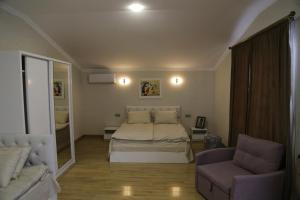 um quarto com uma cama, um sofá e uma cadeira em Hotel 12 Tve em Mtskheta