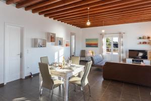 een eetkamer en een woonkamer met een tafel en stoelen bij Petala House in Cherronisos