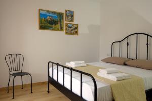 メッツォロンバルドにあるAppartamenti Alle 5 Torriのベッドルーム1室(ベッド1台、椅子付)