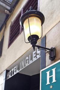a street sign on a pole in front of a building at Hotel Inglés in Barcelona