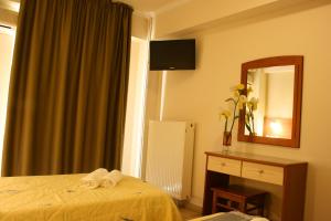 a hotel room with a bed and a mirror at Rea Hotel in Paralia Katerinis