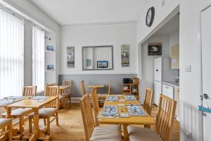een eetkamer met houten tafels en stoelen bij Westbrook Guesthouse in Torquay