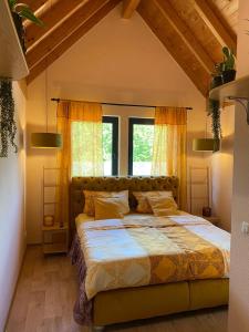 a bedroom with a large bed with yellow curtains at Ferienwohnungen Park Café am Kurpark in Bernkastel-Kues