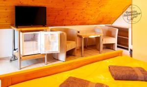 Habitación con TV, mesa y sillas. en Penzion Salamander en Terchová