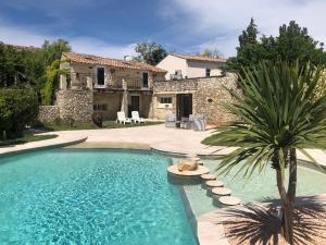 une grande piscine en face d'une maison dans l'établissement Logis Le Mas de Valaurie, à Valaurie