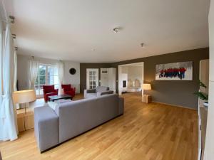uma sala de estar com um sofá cinzento e cadeiras vermelhas em Villa Vahl em Schmallenberg