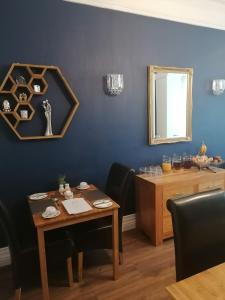 uma sala de jantar com uma mesa e um espelho em The Epperstone em Llandudno