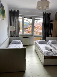 a bedroom with two beds and a large window at EXPO KRUPÓWKI 60 APARTMENT in Zakopane