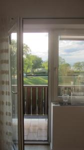 eine offene Tür zu einem Balkon mit Blick auf einen Hof in der Unterkunft Appartement am See in Podersdorf am See