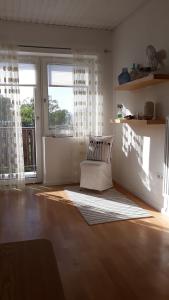 ein Wohnzimmer mit einem Stuhl und einem großen Fenster in der Unterkunft Appartement am See in Podersdorf am See