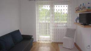 ein Wohnzimmer mit einem Sofa und einem Fenster in der Unterkunft Appartement am See in Podersdorf am See