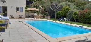 a swimming pool in a yard next to a house at studio 5min plage agosta in Albitreccia +15 photos