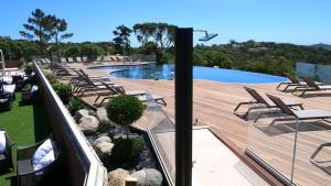 a swimming pool with a deck and chairs and a swimming pool at U Paesolu in Sainte-Lucie de Porto-Vecchio