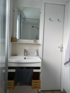 a bathroom with a sink and a mirror at Mobil Home 3 chambres climatisé tout équipé in Valras-Plage