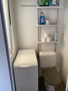 a small bathroom with a toilet and shelves at Mobil Home 3 chambres climatisé tout équipé in Valras-Plage