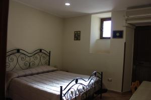 ein Schlafzimmer mit einem Bett und einem Fenster in der Unterkunft Appartamento Gemma in Tropea