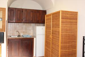 eine Küche mit Holzschränken und einem weißen Kühlschrank in der Unterkunft Appartamento Gemma in Tropea