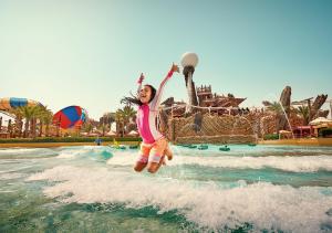 a young girl jumping in the water at a water park at Copthorne Downtown by Millennium in Abu Dhabi