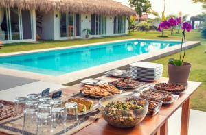 un buffet de comida en una mesa junto a una piscina en Vikara, en Olón