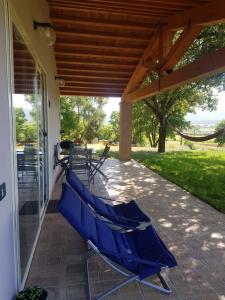 un patio con sillones azules en un porche en When in Maremma en Alberese