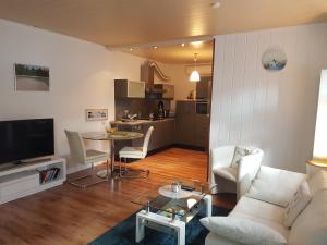 a living room with a couch and a table with chairs at Ferienhaus an den Moorwiesen in Bad Saarow