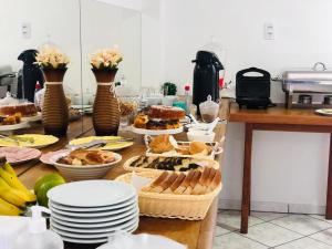 a table topped with plates and baskets of food at Nacional Park Hotel Lages in Lages