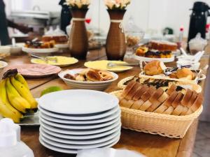 a table topped with plates and baskets of food at Nacional Park Hotel Lages in Lages