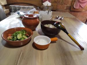 a table with a bowl of food and a bowl of vegetables at House Liteyschika Nikulicheva with Banya in Suzdal