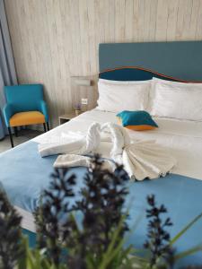 a bedroom with a bed with towels on it at Hotel Riviera in Mamaia