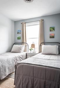 2 camas num quarto com uma janela em “Hygge” 3BDR townhouse, Close to beach, park & wineries! em Traverse City