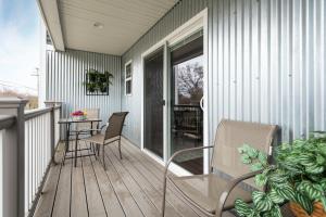 “Hygge” 3BDR townhouse, Close to beach, park & wineries! في ترافيرس سيتي: شرفة شاشة مع طاولة وكراسي على منزل
