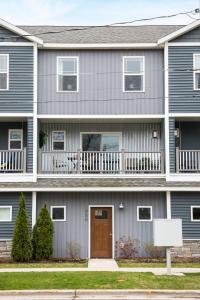 a house with blue siding and a wooden door at “Hygge” 3BDR townhouse, Close to beach, park & wineries! in Traverse City