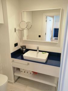 ein Bad mit einem Waschbecken und einem Spiegel in der Unterkunft Subtropik Apartments in Batumi in Batumi