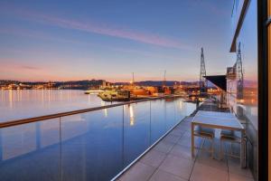 einen Balkon mit einem Tisch und Blick auf das Wasser in der Unterkunft En av Kristiansand's mest eksklusive leiligheter! in Kristiansand